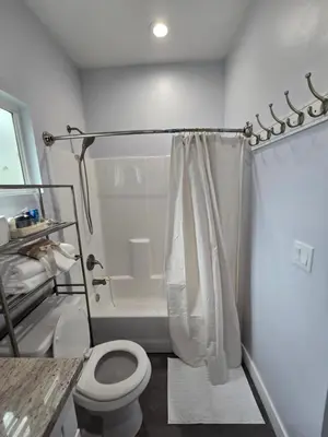 a bathroom with a shower with a toilet and a tub at Cozy 2bdr, 1br home near downtown in Sacramento