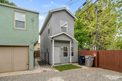 a gray house with a garage next to a fence at Cozy 2bdr, 1br home near downtown in Sacramento