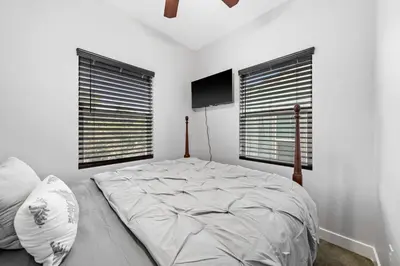 a bedroom with a large bed and two windows at Cozy 2bdr, 1br home near downtown in Sacramento