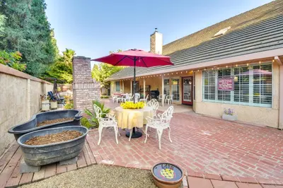 a patio with a table and an umbrella at 1 Mi to Applegate Park Zoo Pet-Friendly Home in Merced
