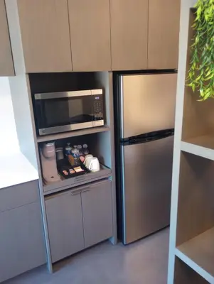 a kitchen with a stainless steel refrigerator and a microwave at My TRI Suites Reno Sparks in Clark