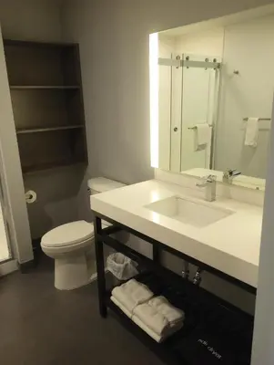 a bathroom with a sink and a toilet and a mirror at My TRI Suites Reno Sparks in Clark