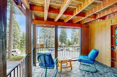 a balcony with two blue chairs and a table at Lakeview Cabin in Tahoma