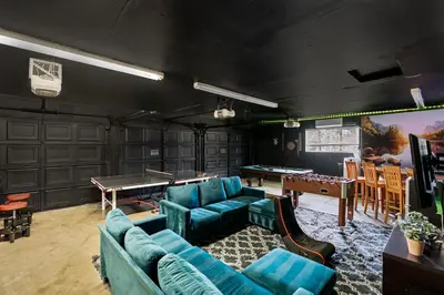 a living room with couches and a ping pong table at Pool-GameRoom-HomeTheater-Bar-PlayStructure-FirePit in Oakhurst