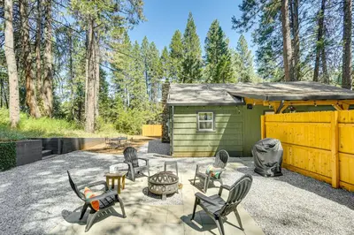 a backyard with chairs and a table and a shed at Walk to Winery Cozy Cabin with Fire Pit in Murphys in Murphys