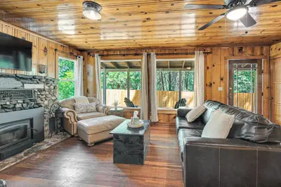 a living room with leather furniture and a fireplace at Walk to Winery Cozy Cabin with Fire Pit in Murphys in Murphys