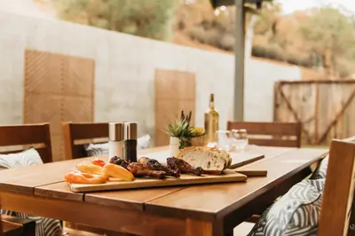 a wooden table with a plate of food on it at Panoramic Lookout Sierra Serenity BBQ by CasaOso in Mariposa