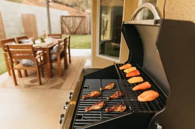 a grill with hot dogs and meat on it at Panoramic Lookout Sierra Serenity BBQ by CasaOso in Mariposa