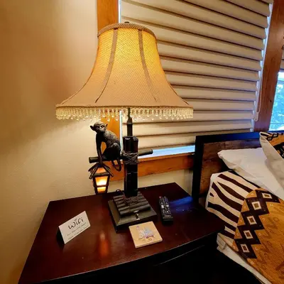 a lamp on a table next to a bed at Kings River Reflections in Sanger