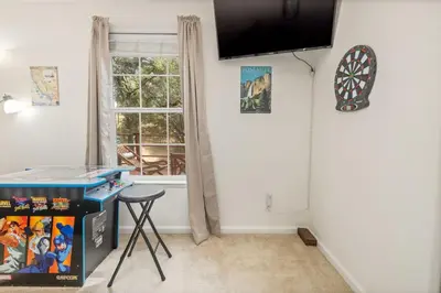 a room with a table and a dart board on the wall at HIlltop Oasis with games, hot tub, Fire-pit, Deck, Views in Oakhurst