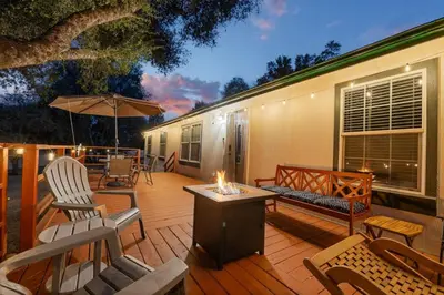 a wooden deck with chairs and a fire pit at HIlltop Oasis with games, hot tub, Fire-pit, Deck, Views in Oakhurst