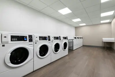 a laundry room with a row of washers and dryers at Residence Inn by Marriott Sacramento Cal Expo in Sacramento