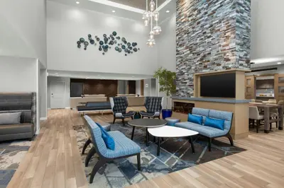 a lobby with chairs and tables and a tv at Residence Inn by Marriott Sacramento Cal Expo in Sacramento
