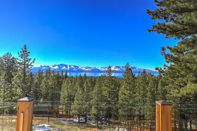 a fence with trees and mountains in the background at Tallac View in Stateline