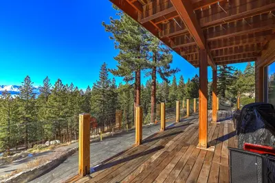 a wooden deck with yellow poles and a tree at Tallac View in Stateline