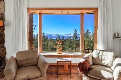 a living room with two chairs and a large window at Tallac View in Stateline
