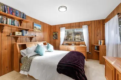 a bedroom with a bed with wooden walls and a window at Tallac View in Stateline