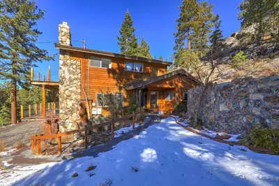 a log home with a fence in the snow at Tallac View in Stateline