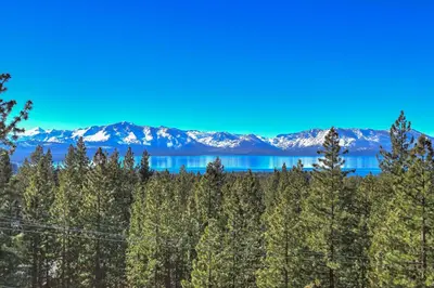 a view of a mountain range with trees and a lake at Tallac View in Stateline