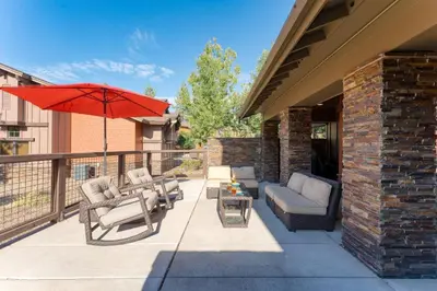 a patio with chairs and an umbrella on a balcony at Luxe All-Season Retreat by AvantStay Prime Location Near Skiing in Truckee