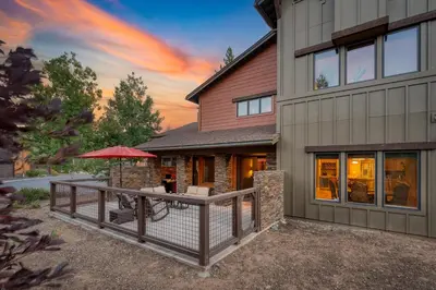 a house with a deck with an umbrella at Luxe All-Season Retreat by AvantStay Prime Location Near Skiing in Truckee