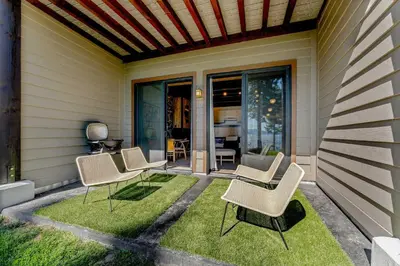 a patio with chairs and grass on the side of a house at Lake Tahoe Vacation Rental w Patio & Pool Access in Kings Beach