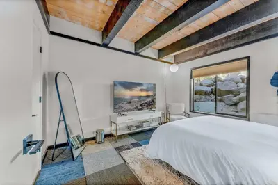 a bedroom with a white bed and a television at Lake Tahoe Vacation Rental w Patio & Pool Access in Kings Beach