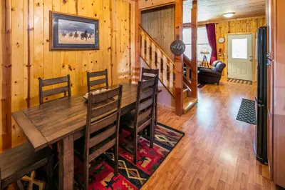 a dining room with a wooden table and chairs at Cabin minutes from Yosemite in Fish Camp