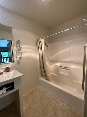 a white bathroom with a shower and a sink at Mi Wuk Village Inn in Mi-Wuk Village