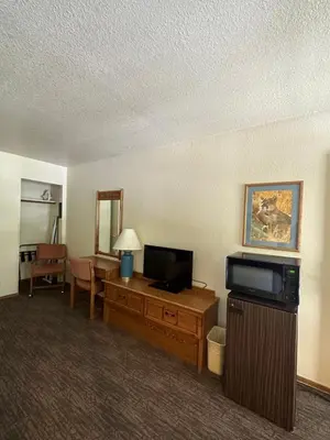 a hotel room with a television and a living room at Mi Wuk Village Inn in Mi-Wuk Village