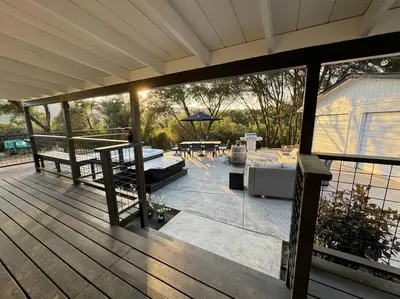 a covered deck with a table and an umbrella at Manzanita Hideaway Hot Tub Sunset views Yosemite in Ahwahnee