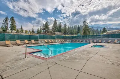 a swimming pool with chairs and a fence at Luxe 4 lake Tahoe Luxury With Hot Tub in Stateline