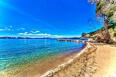 a beach with blue water and a blue sky at Luxe 4 lake Tahoe Luxury With Hot Tub in Stateline