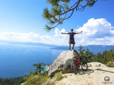 a man standing on top of a rock with his bike at Lv12 luxury villa with hot tub, close to skiing in Glenbrook