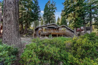 a house with a deck in the woods at Secluded Tahoe Retreat Near Trails and Beach in Carnelian Bay