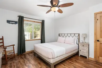 a bedroom with a bed and a ceiling fan at Manzanita Hill-35 miles to Yosemite, 10 miles to Mariposa with 8 person spa in Mariposa
