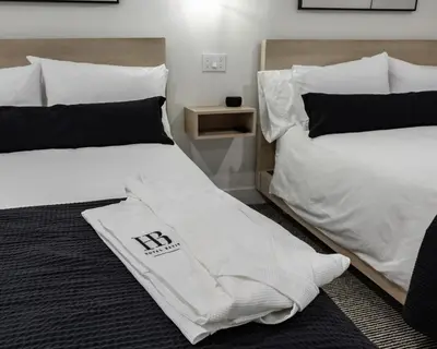 two beds in a room with a towel on them at Hotel Bayit in Modesto