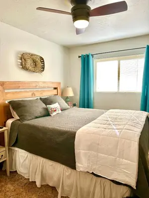 a bedroom with a large bed with a ceiling fan at The Aspen House in Tahoma