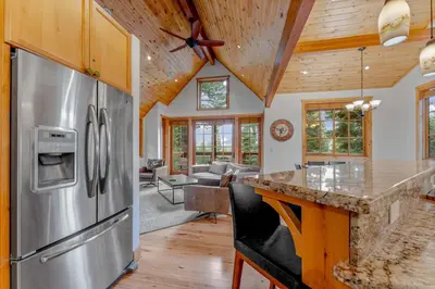 a kitchen with a stainless steel refrigerator and a living room at Northstar Hideaway-Private Hot Tub, Shuttle Access in Truckee