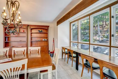 a dining room with a table and chairs and windows at Scenic Home with Sauna - 7 Mi to Heavenly Mountain! in Kingsbury