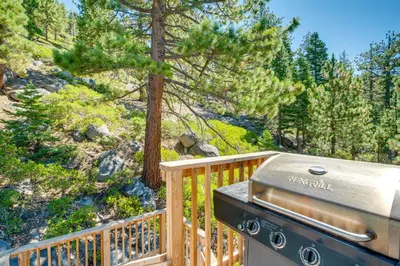a grill on a wooden balcony with trees at Scenic Home with Sauna - 7 Mi to Heavenly Mountain! in Kingsbury