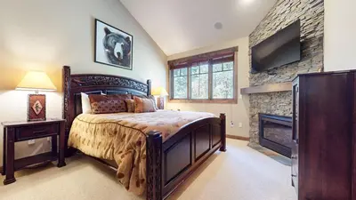 a bedroom with a large bed and a fireplace at Woodwinds #1303 condo in Mammoth Lakes
