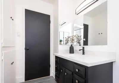 a bathroom with a black and white sink and a mirror at Main Street Retreat in Roseville