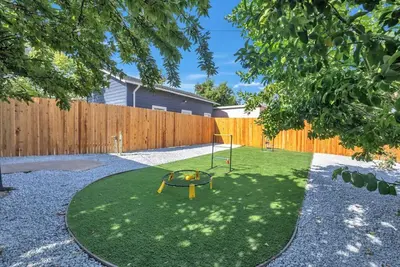 a small yard with a trampoline in the grass at Main Street Retreat in Roseville