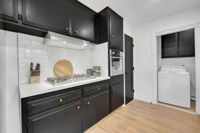 a kitchen with black cabinets and a stove top oven at Main Street Retreat in Roseville