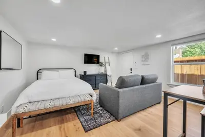 a bedroom with a bed and a couch and a chair at Studio on Main Street in Roseville