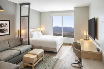 a hotel room with a bed and a couch at Hyatt Place Reno in Reno