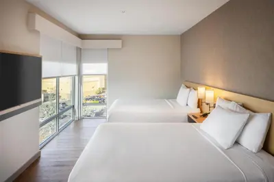 two beds in a hotel room with a large window at Hyatt Place Reno in Reno