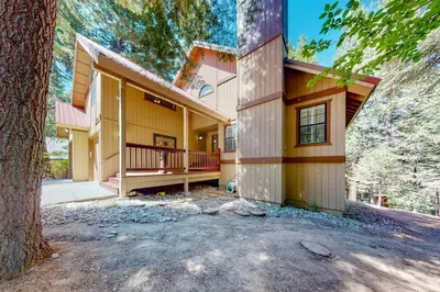 a large yellow house with a tree in front of it at Windwood Inn in Shaver Lake