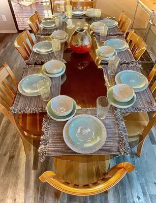 a wooden table with plates and glasses on it at Spacious sequoia Park retreat, best panoramic views in Three Rivers